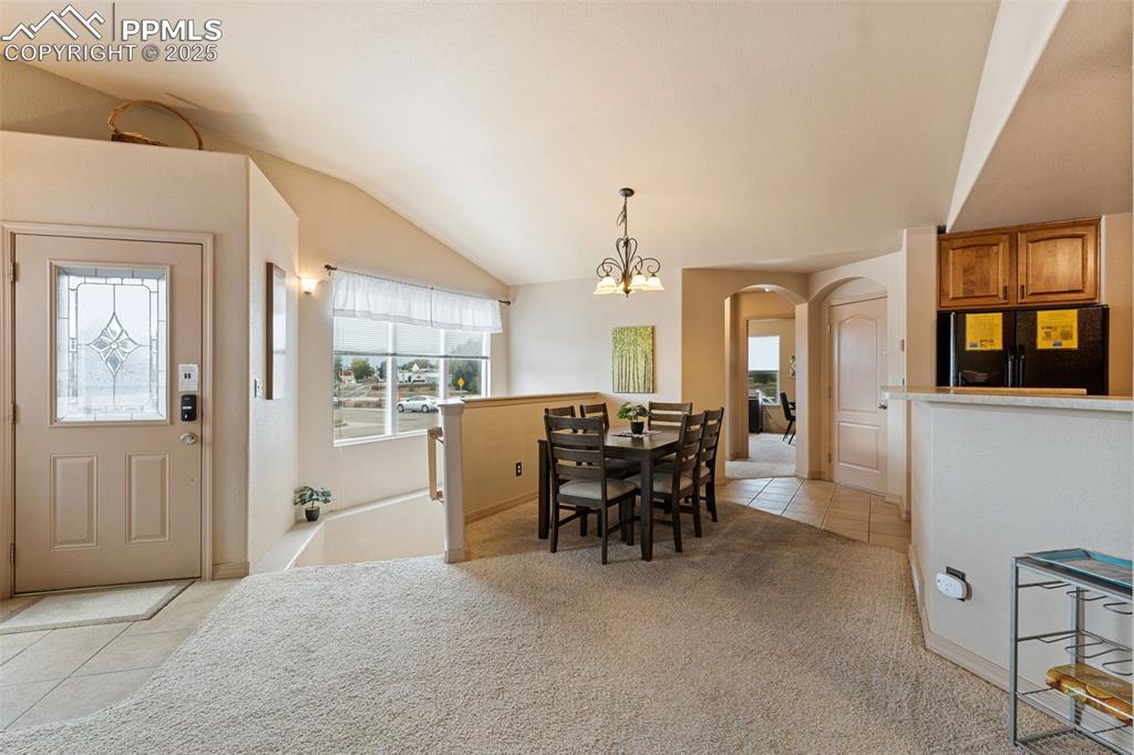 Image 3 of 27: Dining area featuring light tile patterned floors, arched walkways, lofted