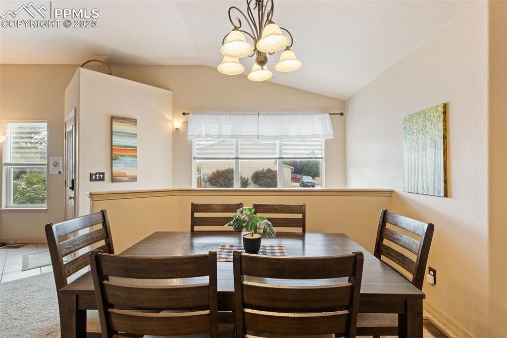 Image 8 of 27: Dining room featuring lofted ceiling and a chandelier