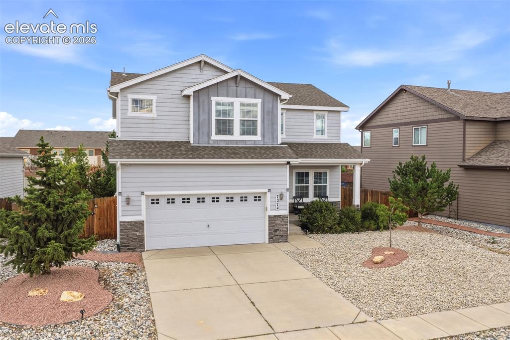 Caption: Two-story residence featuring light gray siding, dark gray board and batten accents, and a two-car g