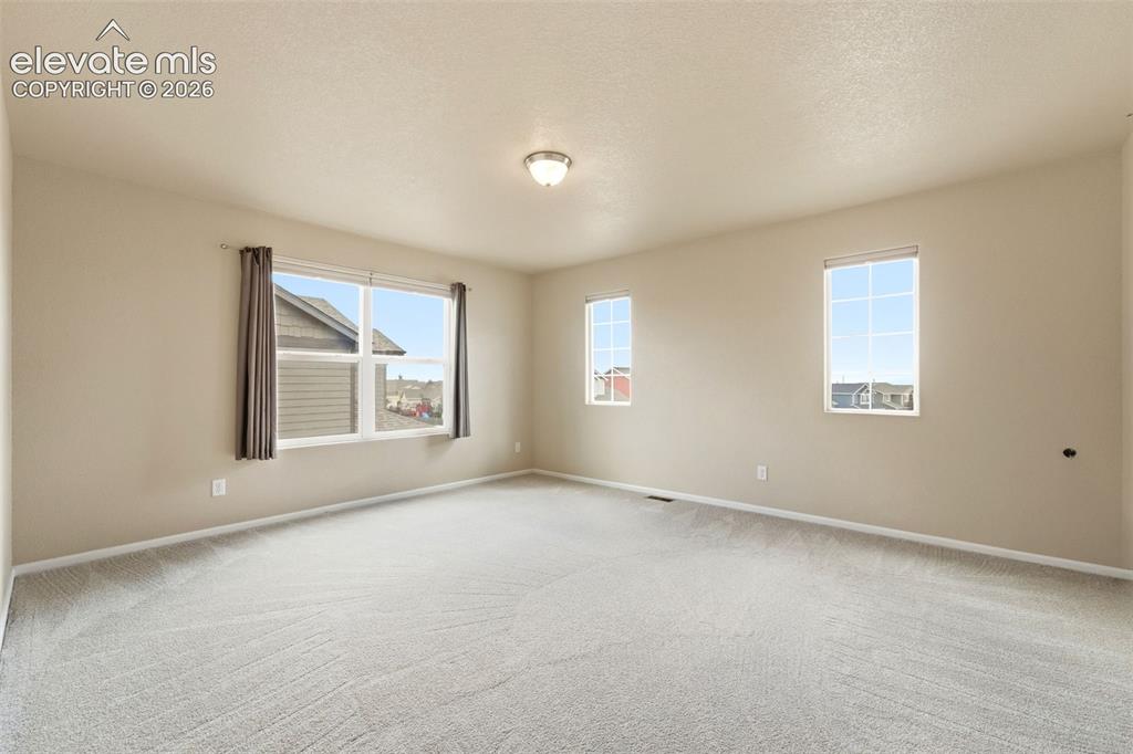 Image 11 of 33: Light-toned wall paint, multiple windows, recessed lighting, and carpeted f