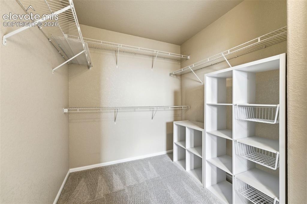Image 22 of 33: Built-in closet organization system featuring wire shelving, wire hanging r