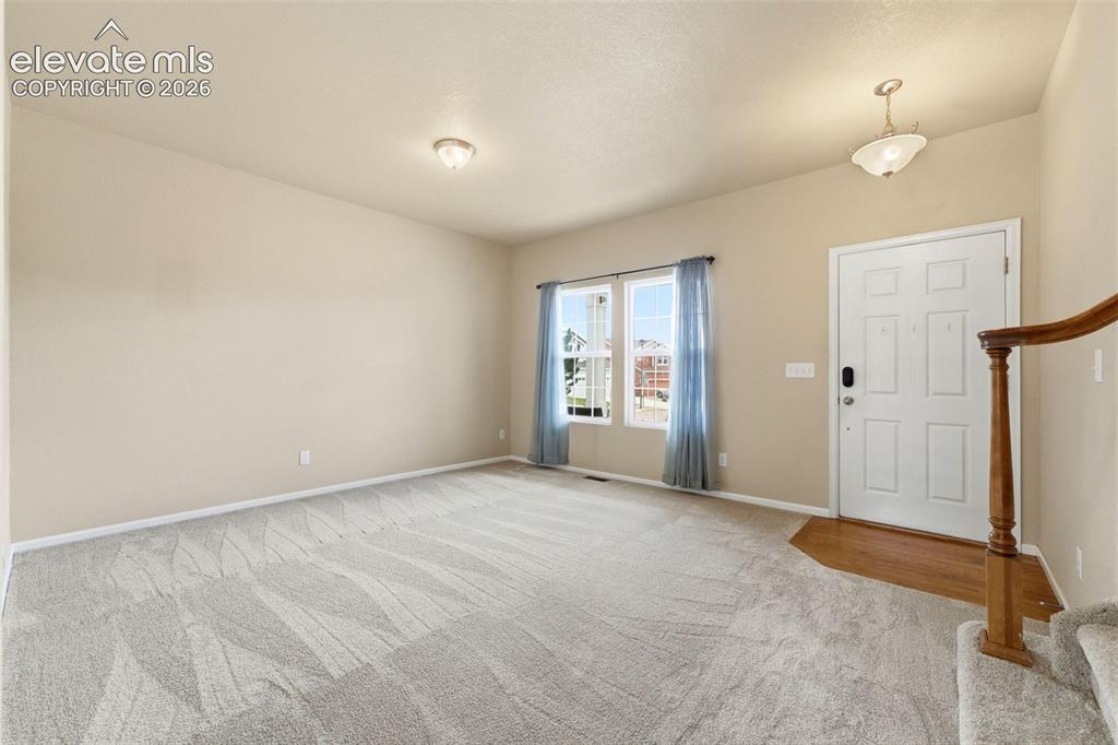 Image 4 of 33: NEW CARPET throughout home. Hardwood flooring entryway leading to a carpet