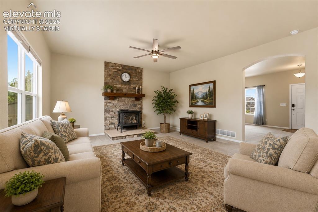 Image 5 of 33: *Virtually Staged*
Spacious living area featuring a stone fireplace with a