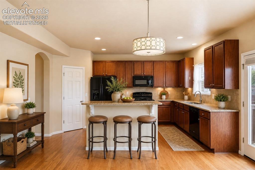 Image 7 of 33: *Virtually Staged*
Kitchen featuring wood-finish flooring, wood cabinetry,