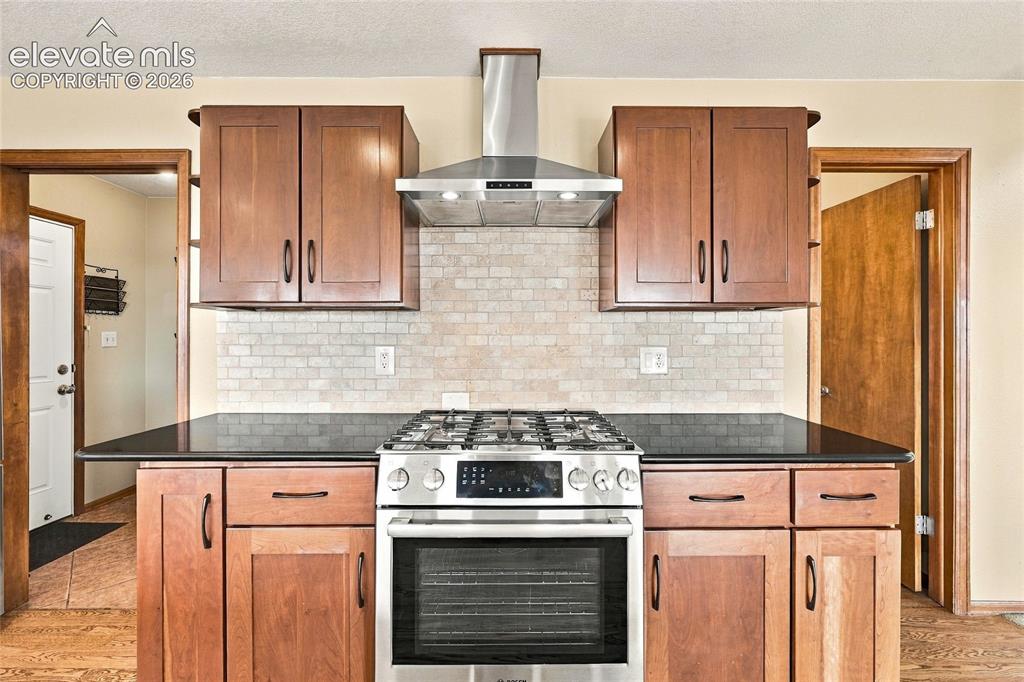 Image 15 of 50: gas stove and stainless steel hood
