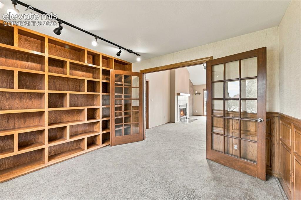Image 24 of 50: office with built in shelving and wall panels