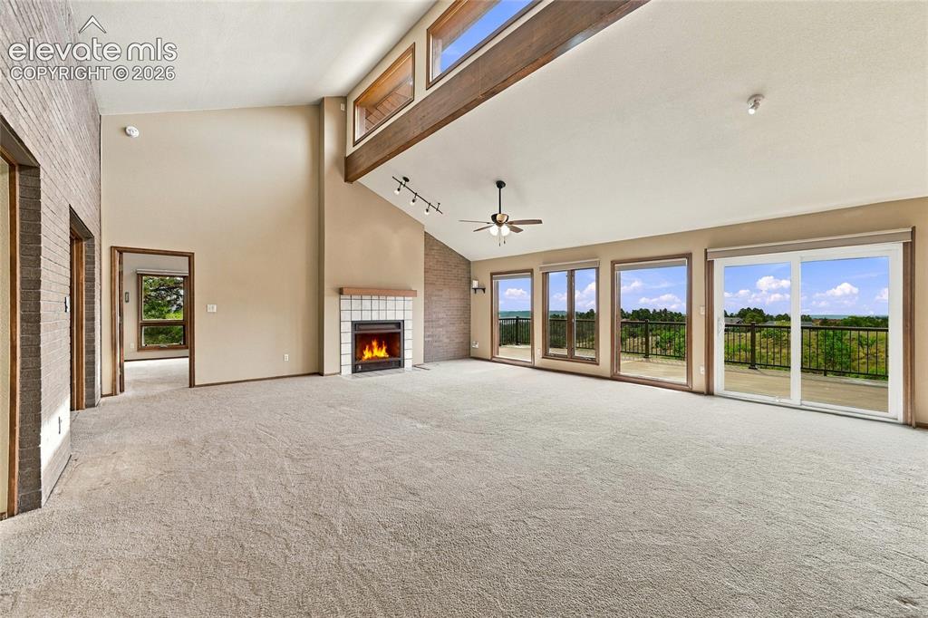 Image 5 of 50: Living room with massive views and fireplace, vaulted ceiling