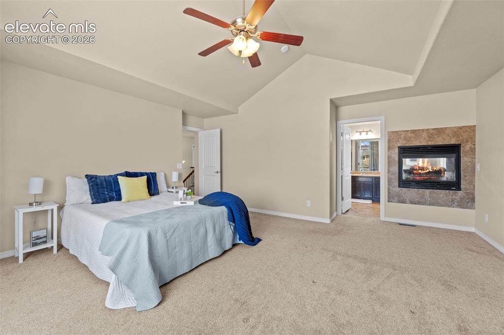 Image 21 of 44: primary with double sided fireplace into tub area of bath