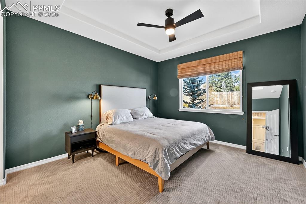 Image 17 of 32: inviting primary bedroom with coffered ceiling