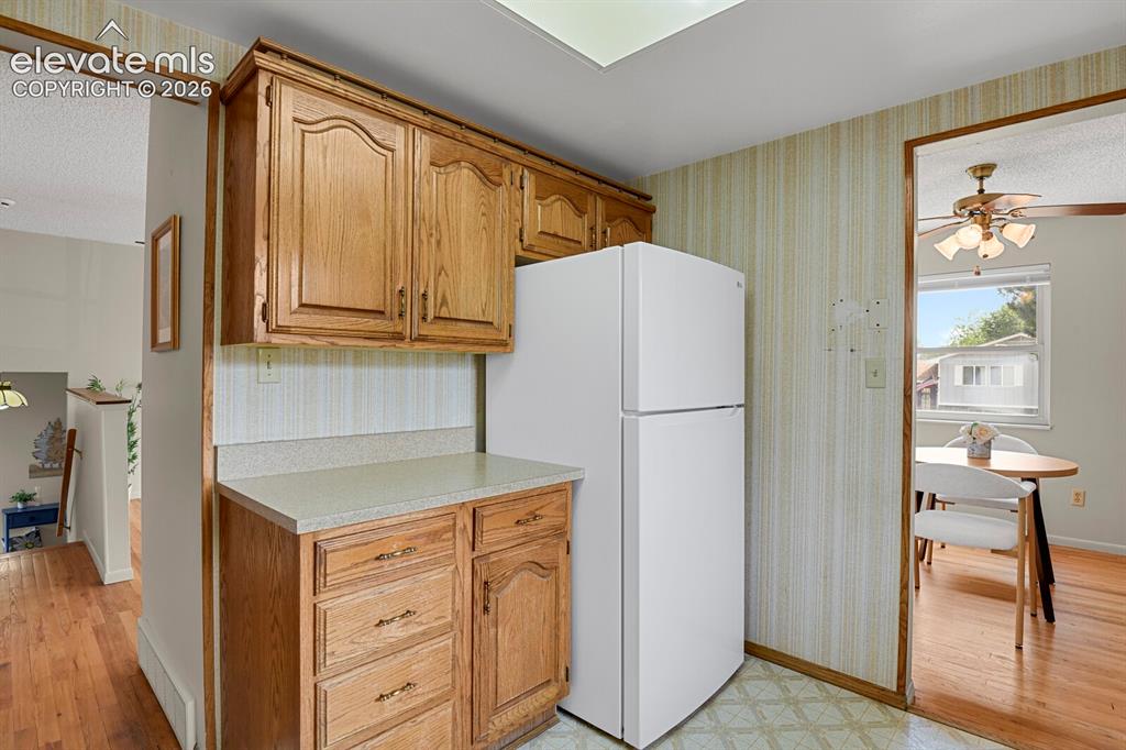 Image 18 of 48: Kitchenette featuring wood-finish cabinetry, light-toned countertop, and pa