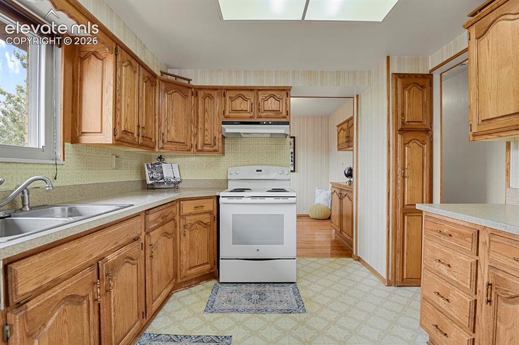 Image 19 of 48: Kitchen featuring extensive wood cabinetry, laminate countertops, a double