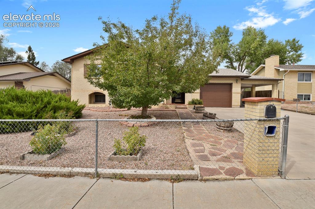 Image 2 of 48: Brick exterior residence with an attached garage, a covered carport