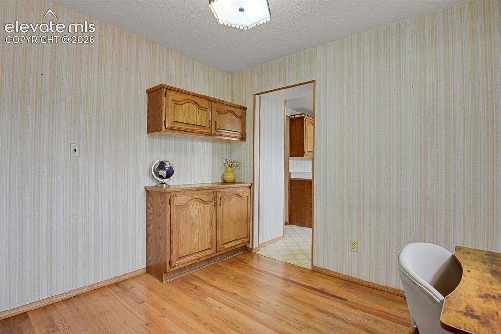 Image 21 of 48: Wood-finish flooring with built-in wood cabinetry featuring storage and upp