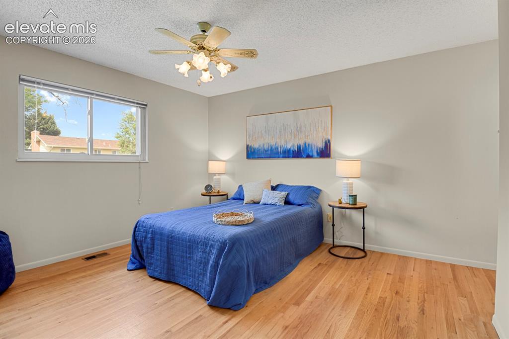 Image 22 of 48: Hardwood floors, a ceiling fan with integrated lighting, and a window provi