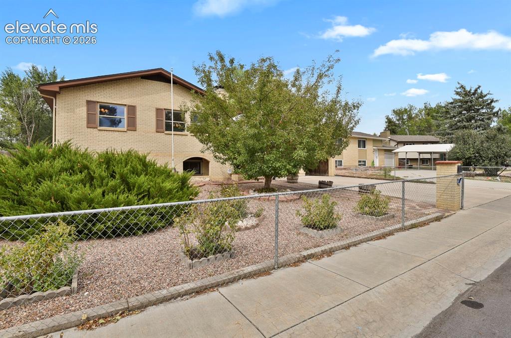 Image 3 of 48: Light-colored brick exterior with dark brown trim, windows featuring decora