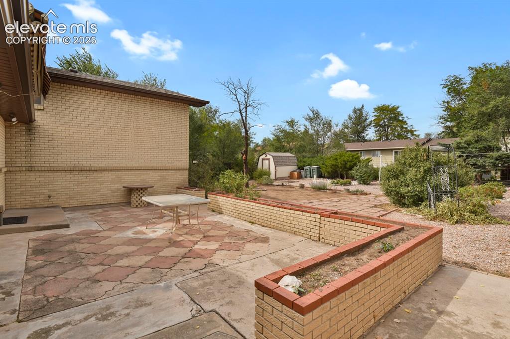 Image 41 of 48: Expansive patio area with checkered paver design