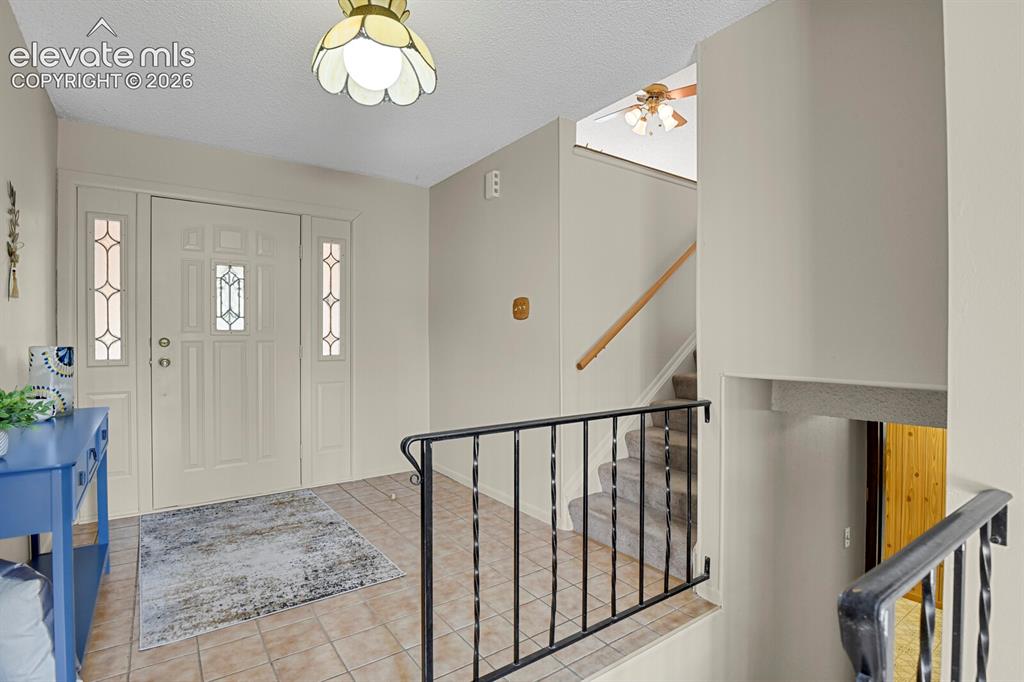 Image 7 of 48: Entryway featuring a decorative front door with sidelights, tile flooring, 