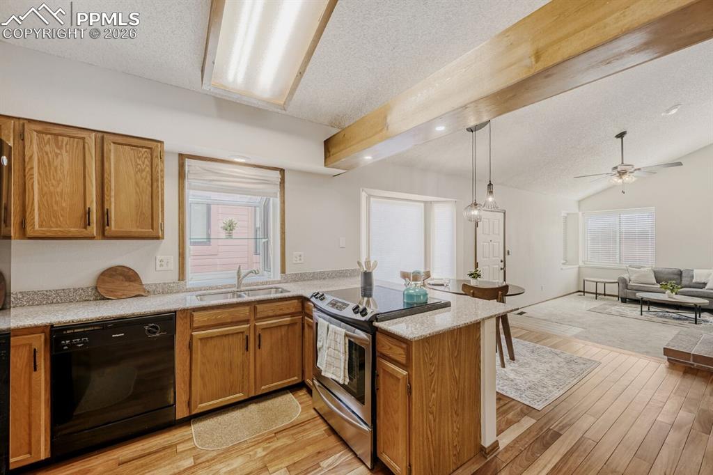 Image 11 of 34: Kitchen featuring stainless steel range with electric cooktop, wood finish 