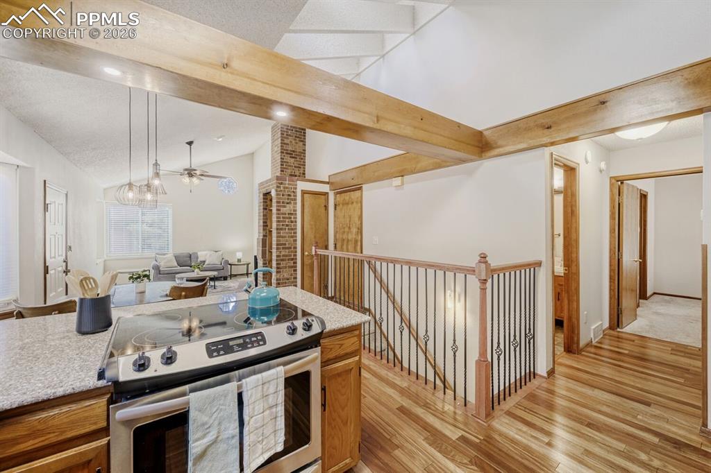 Image 12 of 34: Kitchen with stainless steel electric stove, light wood-style floors, vault