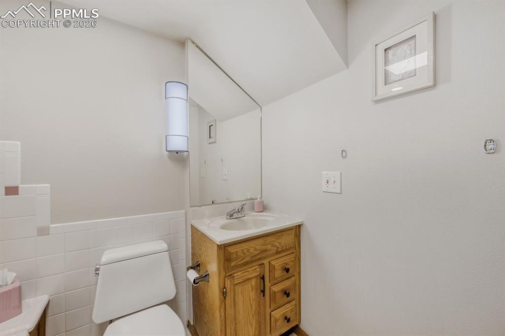 Image 16 of 34: Bathroom featuring vanity, tile walls, and wainscoting