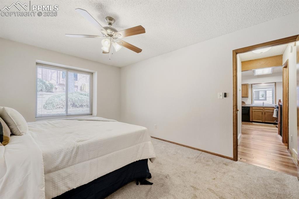 Image 19 of 34: Bedroom featuring light colored carpet, ceiling fan, and a textured ceiling