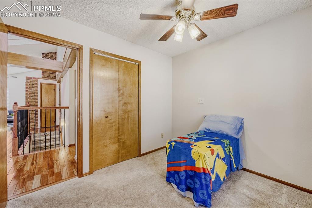 Image 23 of 34: Unfurnished bedroom with a textured ceiling, ceiling fan, and carpet