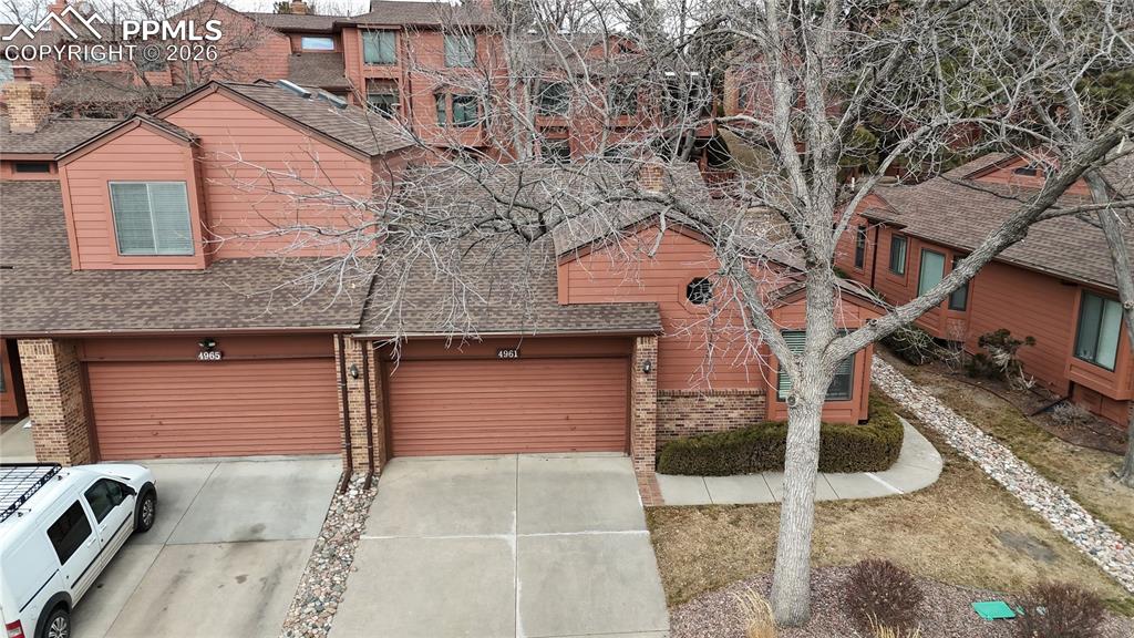 Image 29 of 34: Chalet / cabin featuring brick siding, driveway, roof with shingles, and an