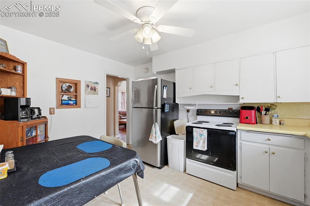 Image 12 of 23: Kitchen with white range with electric stovetop, light countertops, freesta