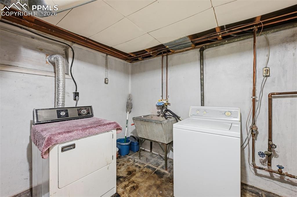 Image 22 of 23: Laundry area with washer and clothes dryer and unfinished concrete floors