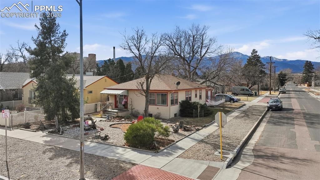 Image 5 of 23: Back of property with a mountain view, stucco siding, and a residential vie