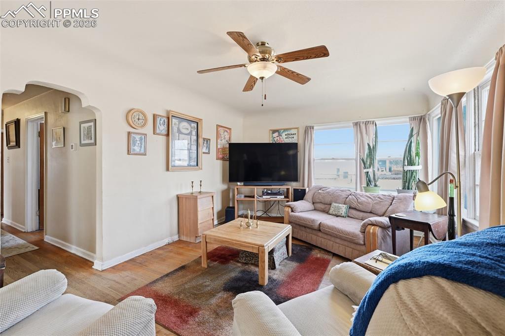 Image 8 of 23: Living room featuring arched walkways, wood finished floors, and a ceiling