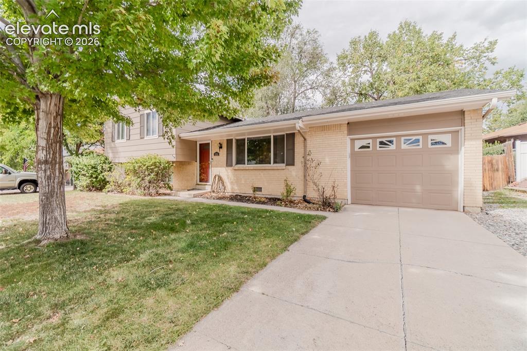Image 1 of 42: Ranch-style exterior featuring a light brick facade, attached garage with d