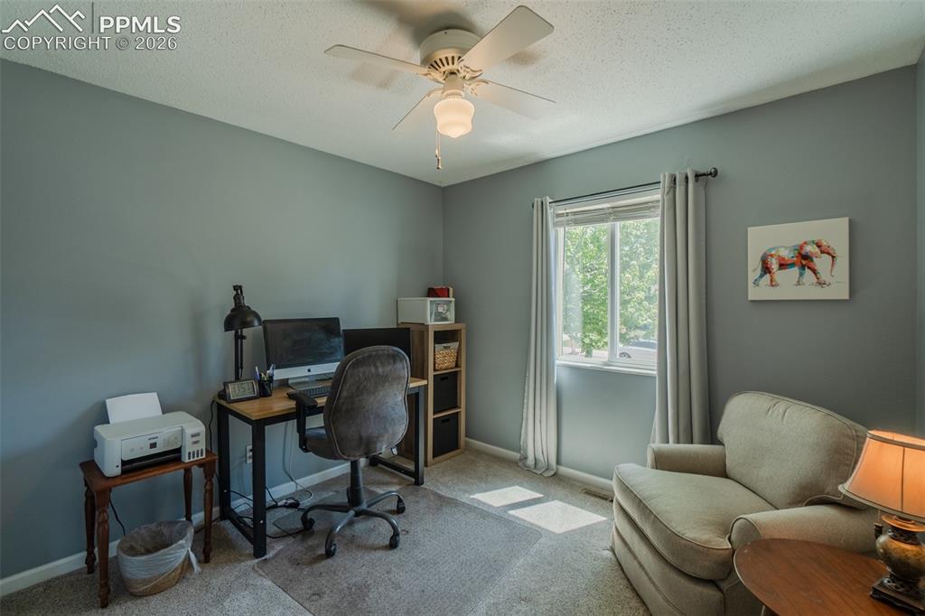 Image 13 of 31: One of three Bedrooms currently used as an office.  Featuring light gray wa