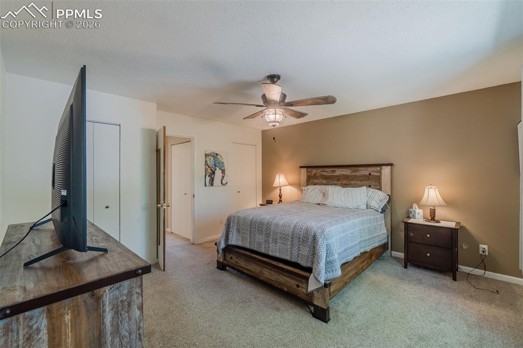 Image 14 of 31: Carpeted Primary bedroom featuring a ceiling fan with light fixture, two-to