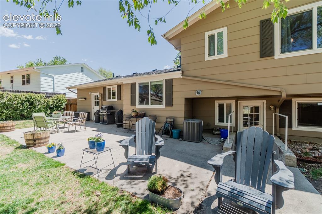Image 15 of 30: Expansive concrete patio with direct access to the interior, featuring mult