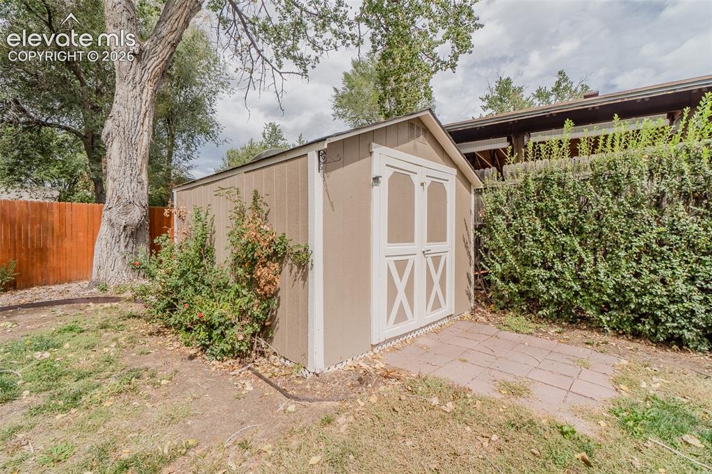 Image 17 of 42: Outdoor storage shed with double doors, wood siding, and an asphalt shingle