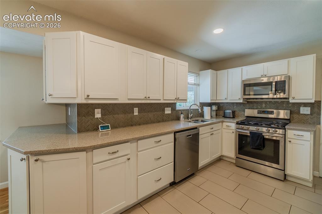 Image 2 of 30: Kitchen featuring gas oven, white shaker cabinetry, stainless steel applian