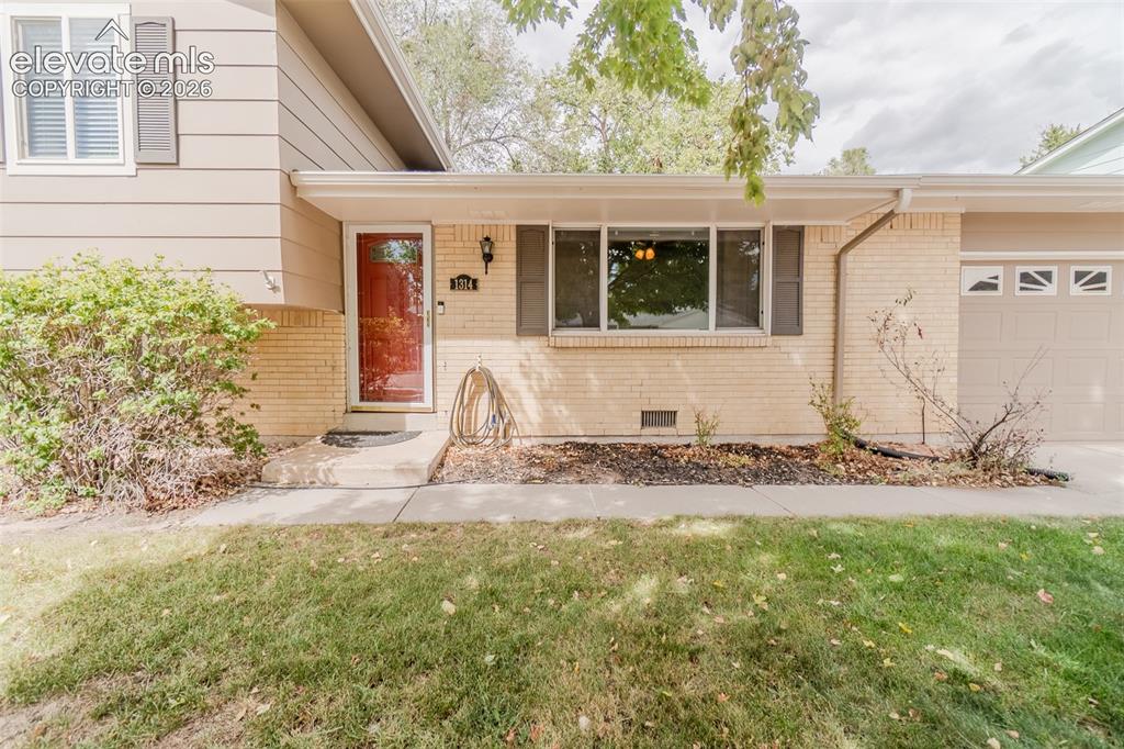 Image 2 of 42: Brick and siding exterior with a red front door