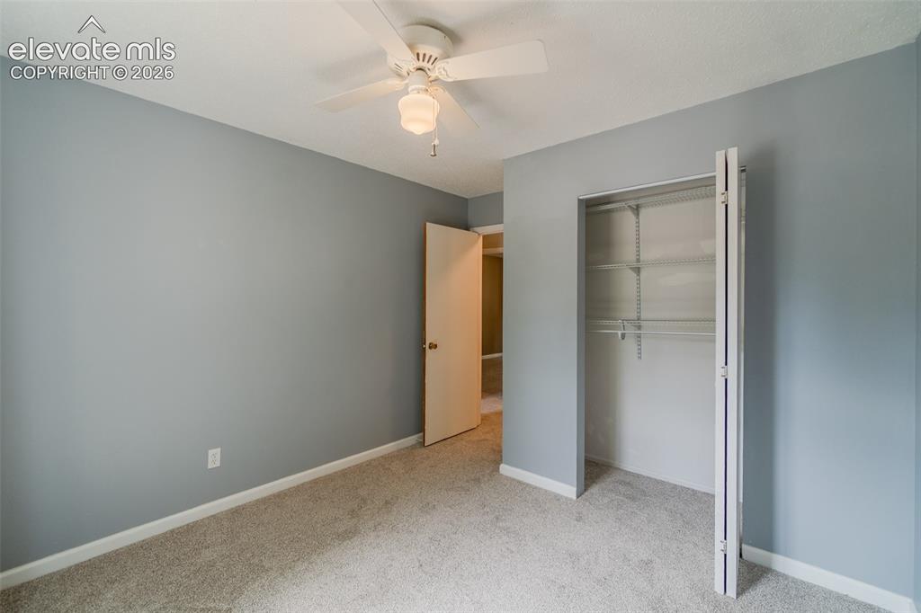 Image 20 of 42: Carpeted flooring, ceiling fan, bi-fold closet, and neutral wall color