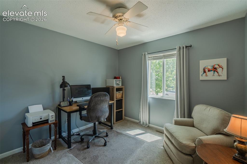 Image 21 of 30: One of three Bedrooms currently used as an office. Featuring light gray wa