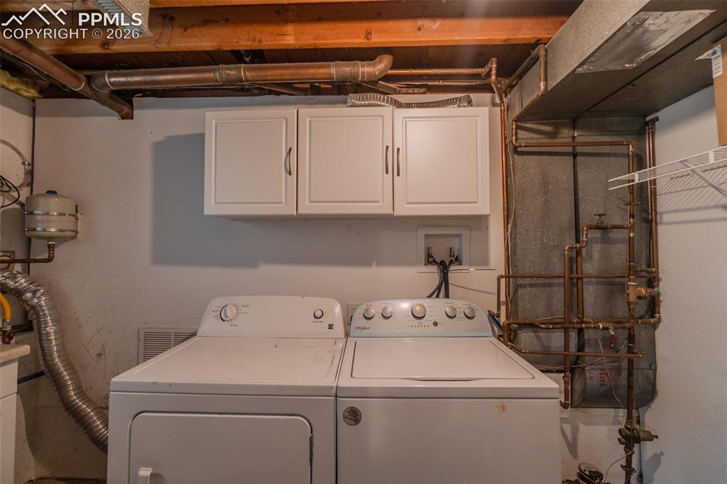 Image 22 of 31: Washer dryer will stay.  Copper pipes.  Tankless water heater, expansion ta
