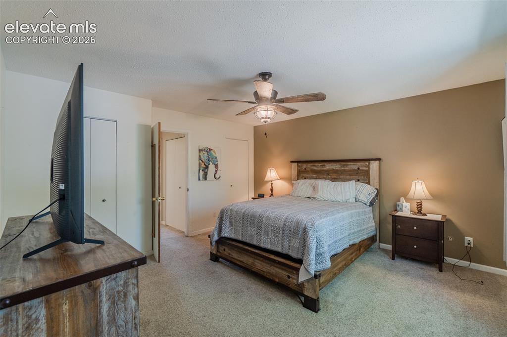Image 22 of 30: Carpeted Primary bedroom featuring a ceiling fan with light fixture, two-to