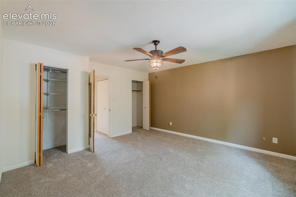 Image 25 of 42: Neutral tone wall, textured ceiling, ceiling fan with integrated lighting,