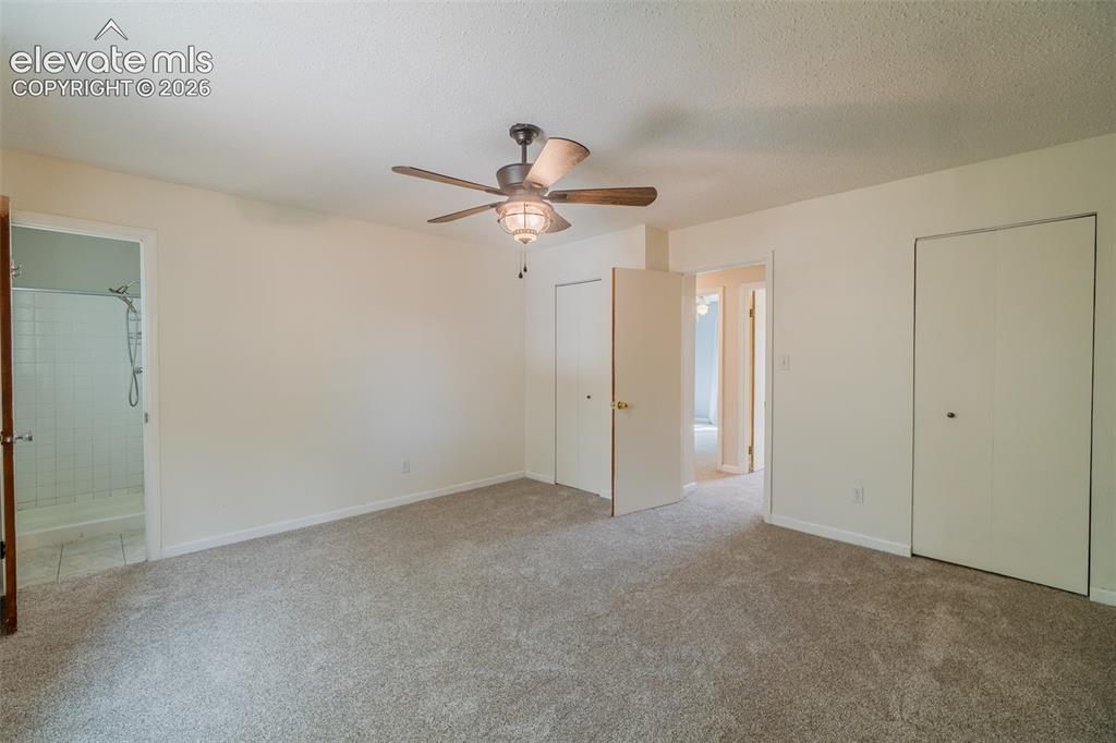 Image 27 of 42: Carpeted room featuring a ceiling fan with light fixture, two bi-fold door