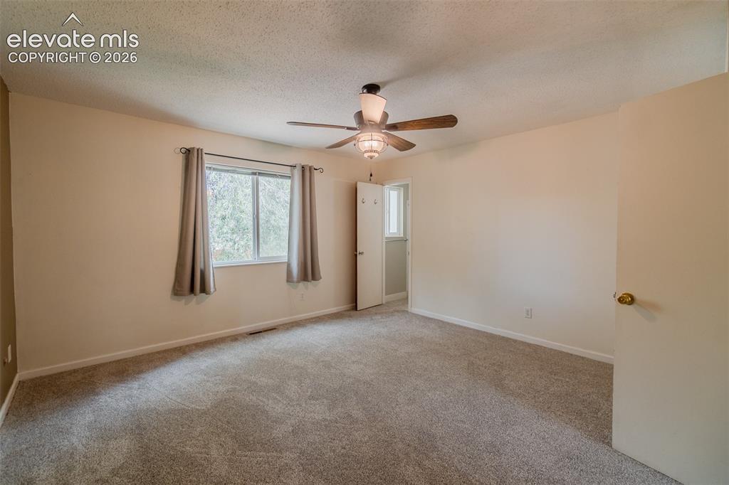 Image 28 of 42: Spacious room featuring neutral carpeting, a ceiling fan with integrated li