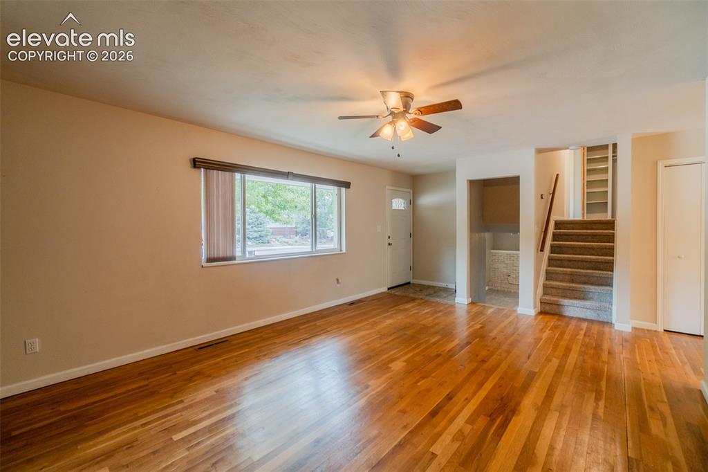 Image 3 of 42: Spacious open living area showcasing gleaming wood-finish flooring, abundan