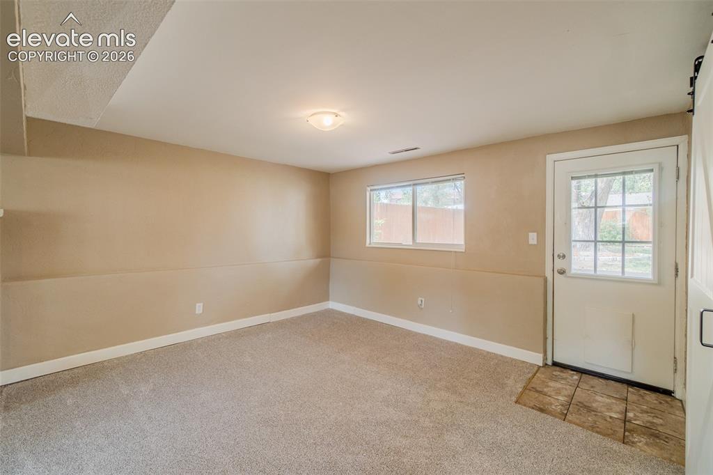 Image 32 of 42: Neutral tone wall paint, carpeted flooring, flush mount ceiling light, exte