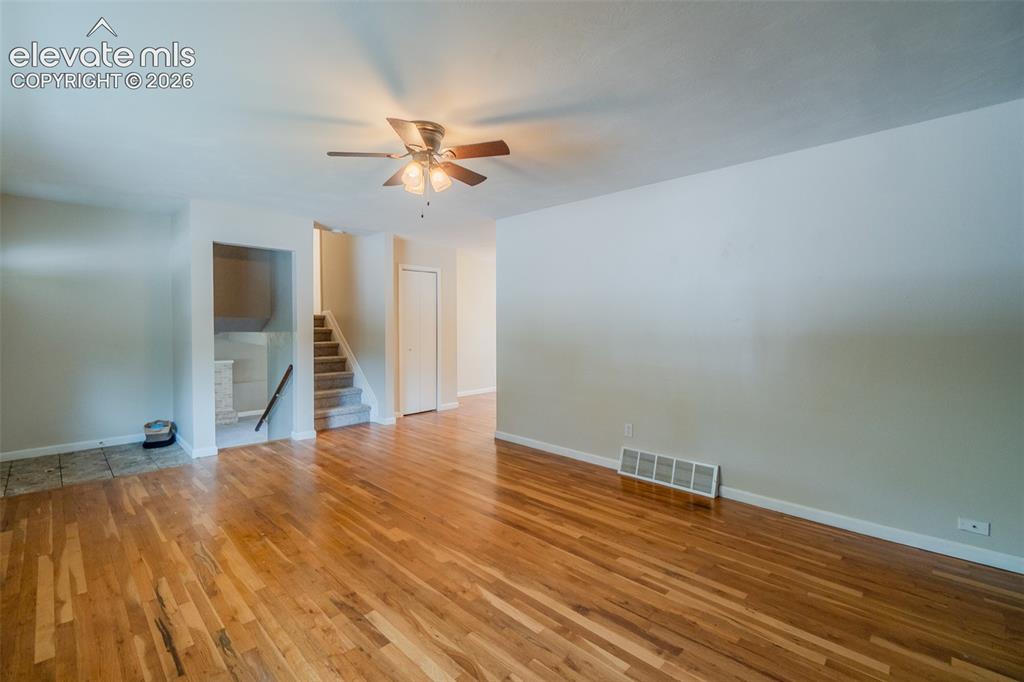 Image 4 of 42: Hardwood flooring, ceiling fan with integrated lighting, interior staircase
