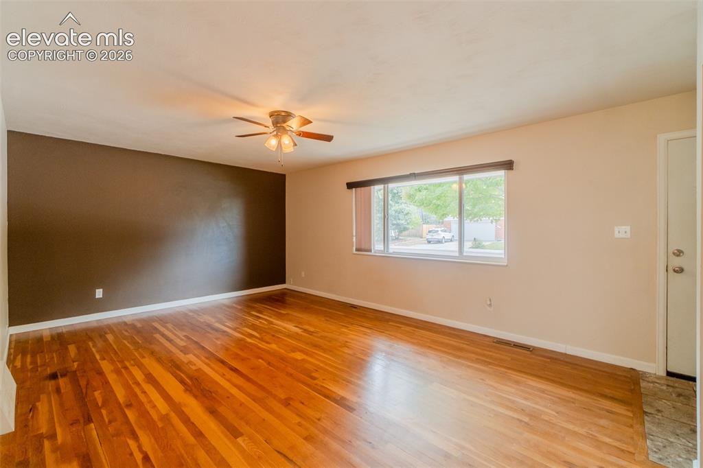 Image 42 of 42: Hardwood flooring, ceiling fan with integrated lighting, large window with
