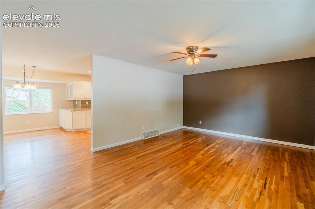 Image 5 of 42: Hardwood flooring, painted accent wall, ceiling fan with integrated lightin